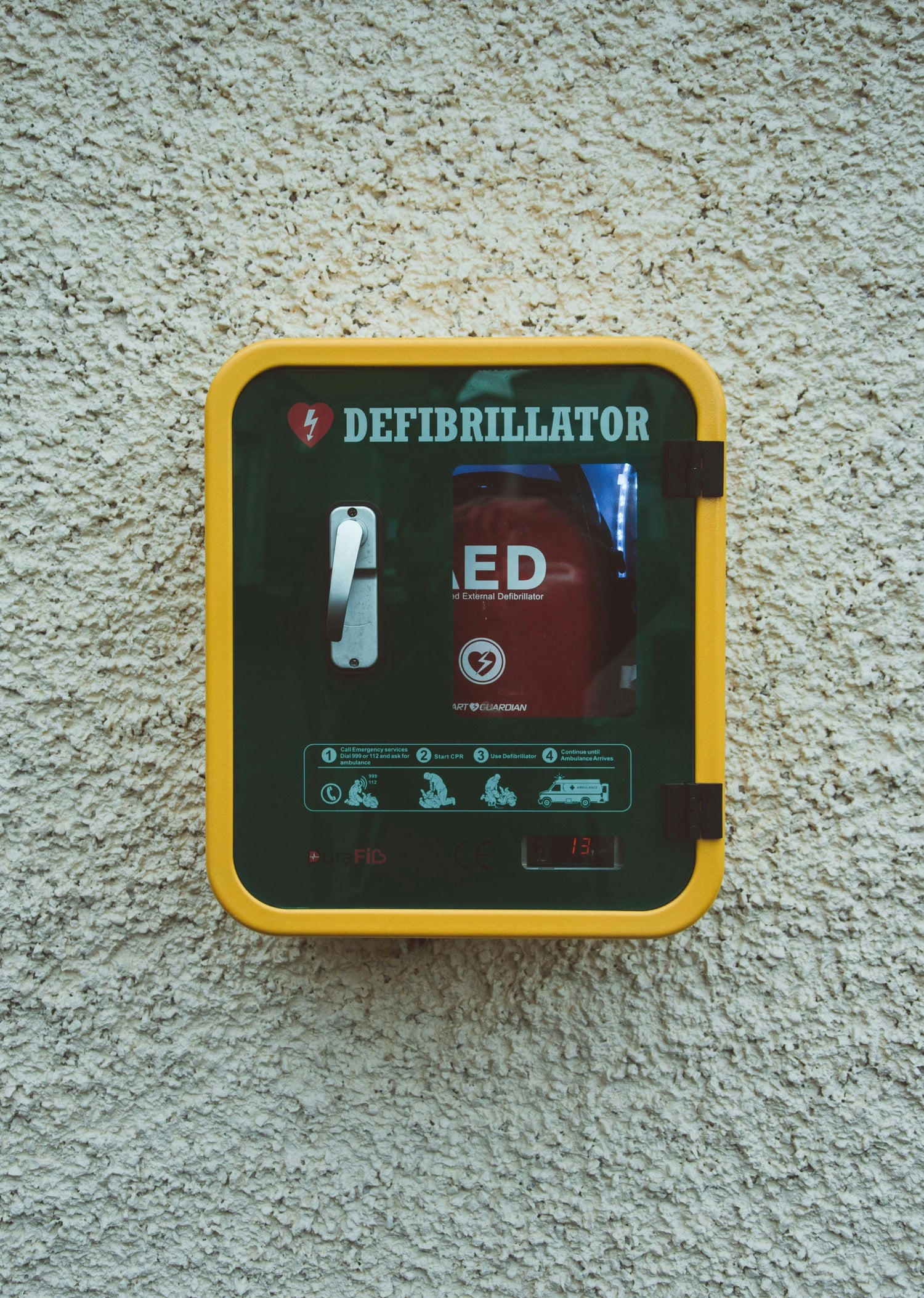 Defibrillator on fence outdoors